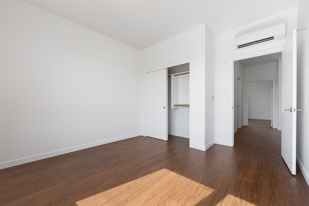 A room with wooden floors and white walls with two doors.